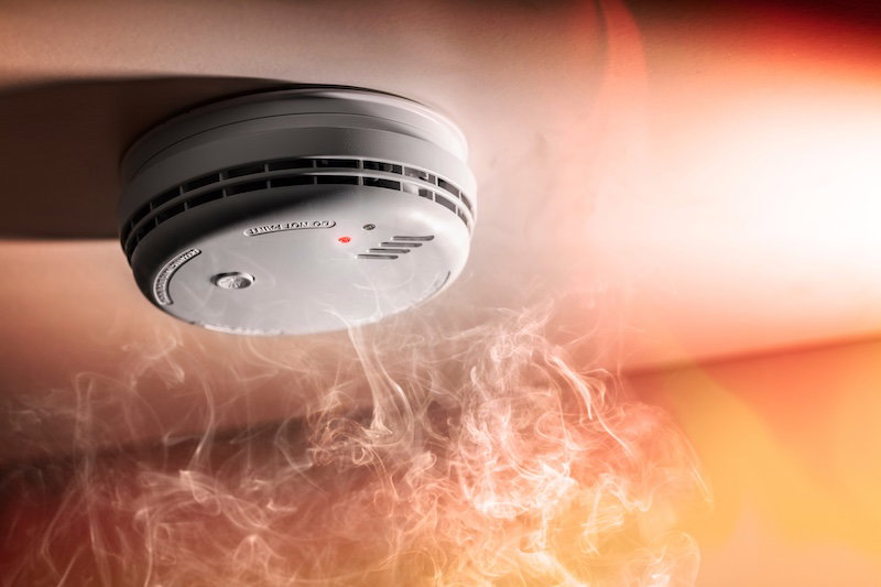 Smoke alarm with visible smoke highlighting fire safety for people with hearing loss